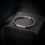 Two-tone men's bracelet with black ceramic links, rose gold bar, and red zircon accents