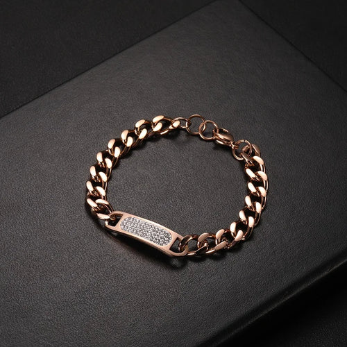 Rose gold men's curb chain bracelet with a pavé diamond ID bar on black surface
