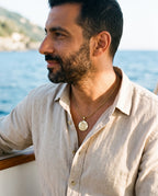 Man wearing the Marco Maveri Archangel Medallion Snake Chain Necklace by the sea, Gold