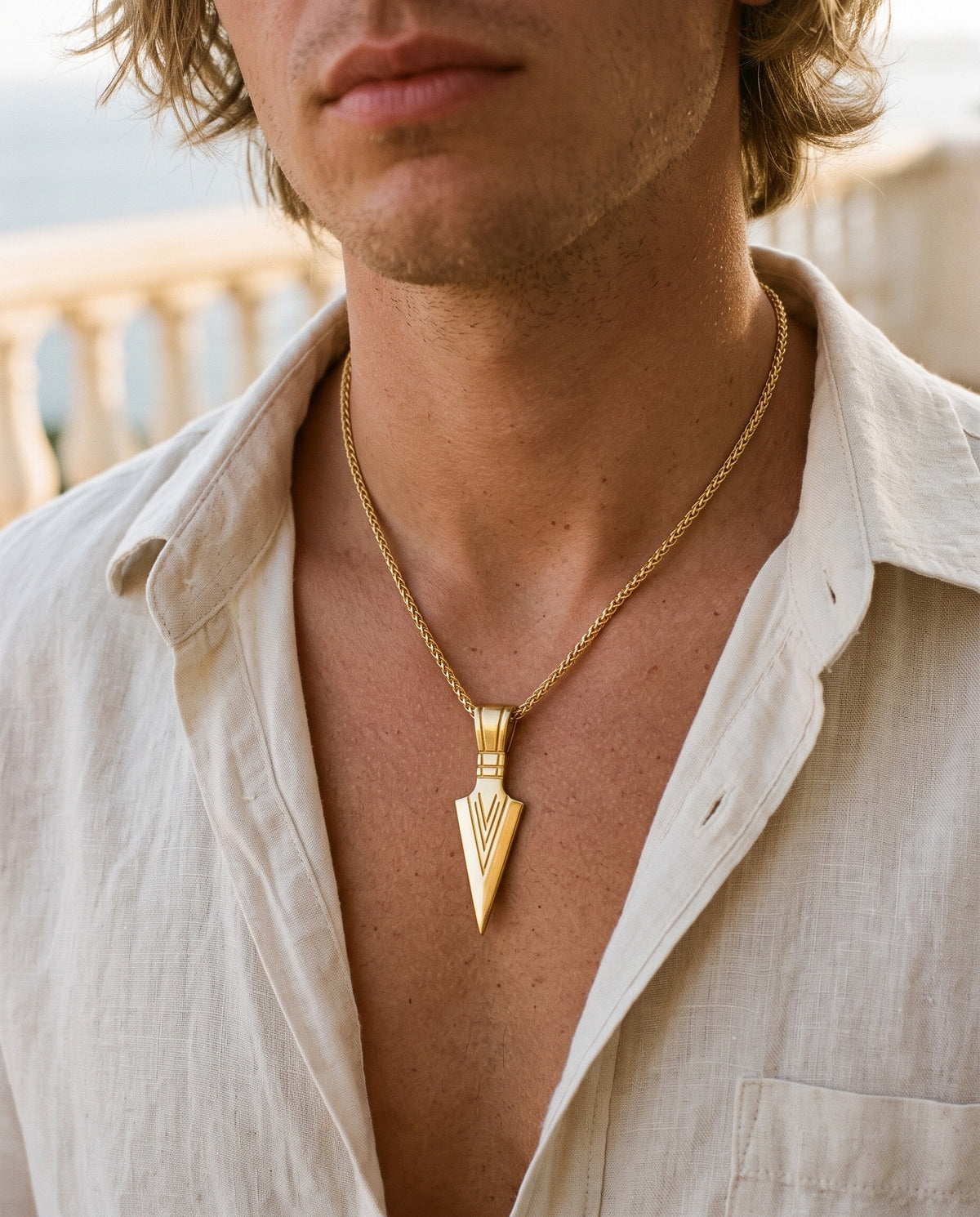 Marco Maveri Arrowhead Pendant Wheat Chain Necklace worn with a linen shirt, close-up, Gold