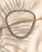 Marco Maveri Bold Cuban Link Chain in Titanium Steel laid on cream linen, Silver