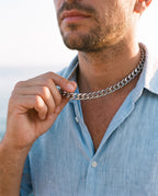 Man adjusting the Marco Maveri Bold Cuban Link Chain in Titanium Steel, close-up, Silver