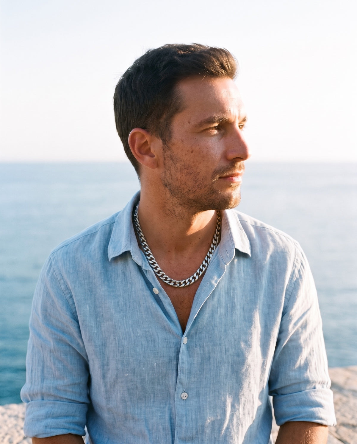 Man wearing the Marco Maveri Bold Cuban Link Chain in Titanium Steel by the sea, Silver