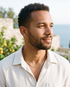 Man wearing the Marco Maveri Box Chain Necklace in Titanium Steel by the sea, Gold