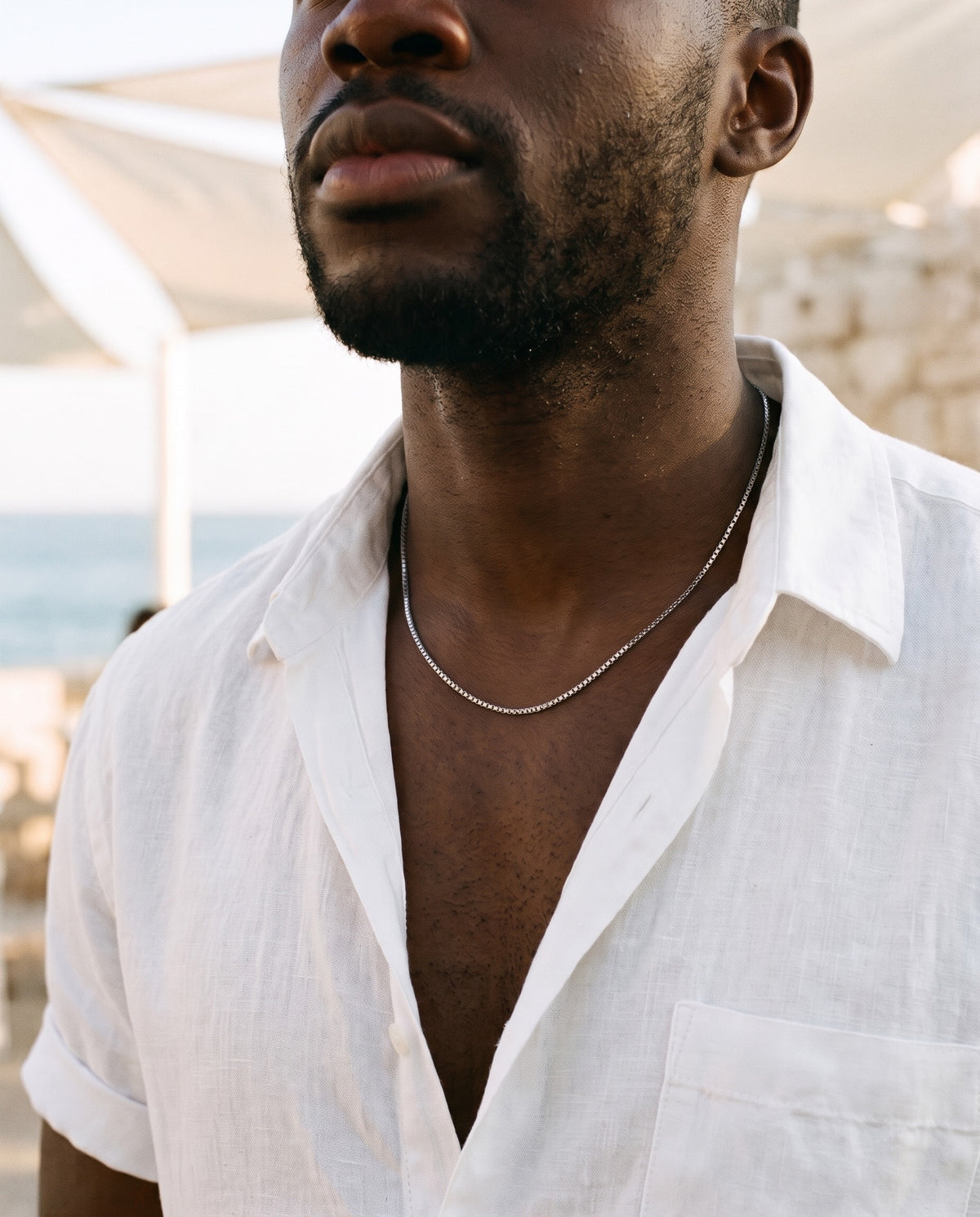 Marco Maveri Box Chain Necklace in Titanium Steel worn with a linen shirt, close-up, Silver