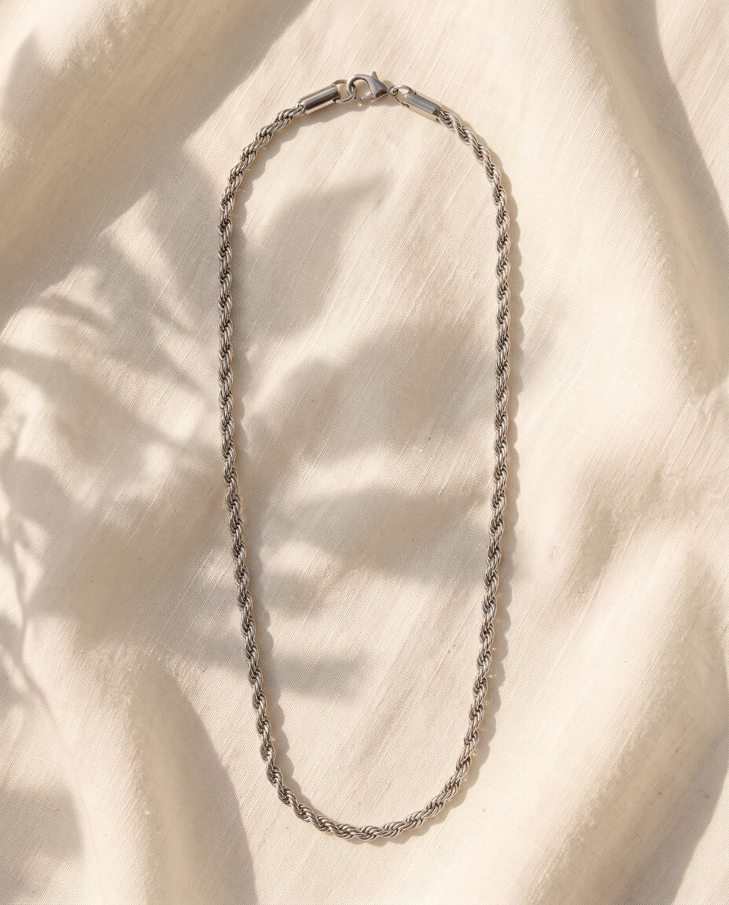 Marco Maveri Braided Titanium Steel Chain laid on cream linen, Silver