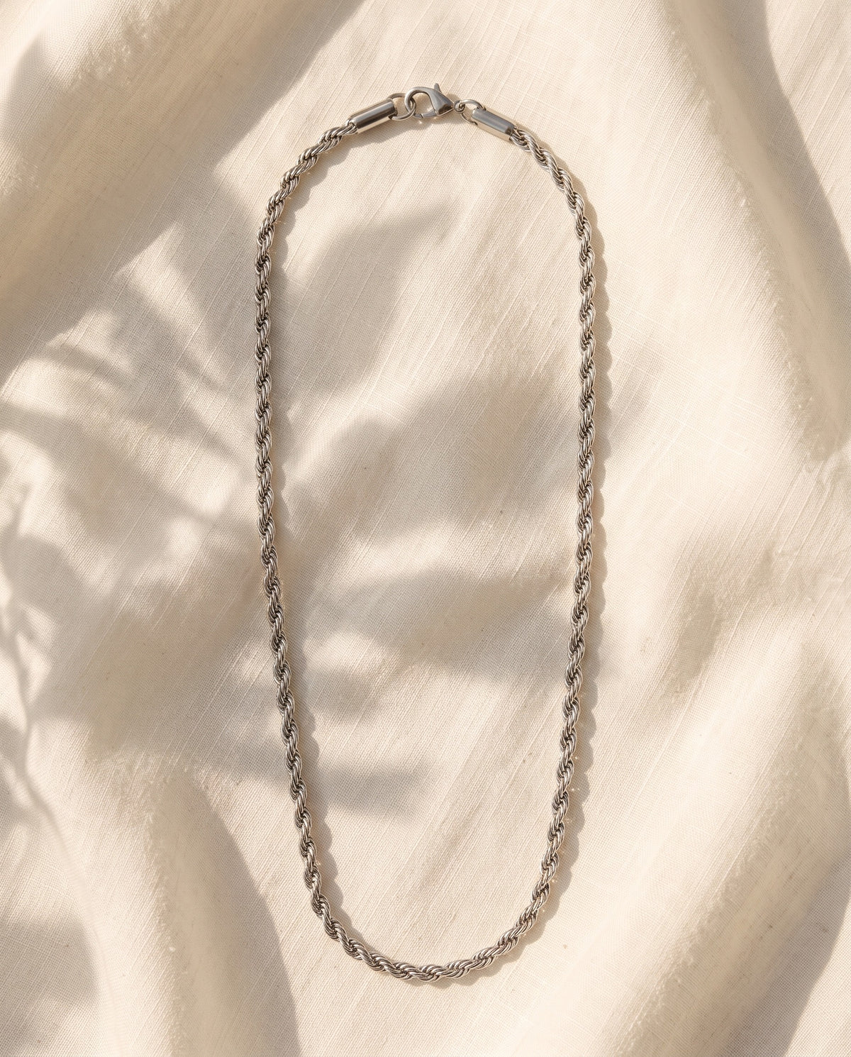 Marco Maveri Braided Titanium Steel Chain laid on cream linen, Silver