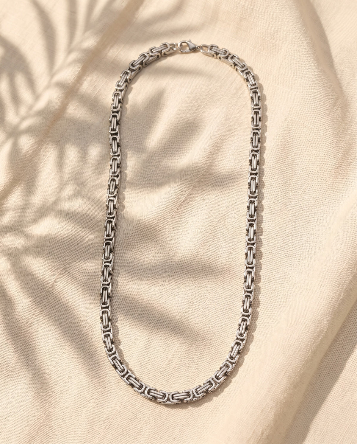 Marco Maveri Byzantine Chain in Stainless Steel laid on cream linen, Silver