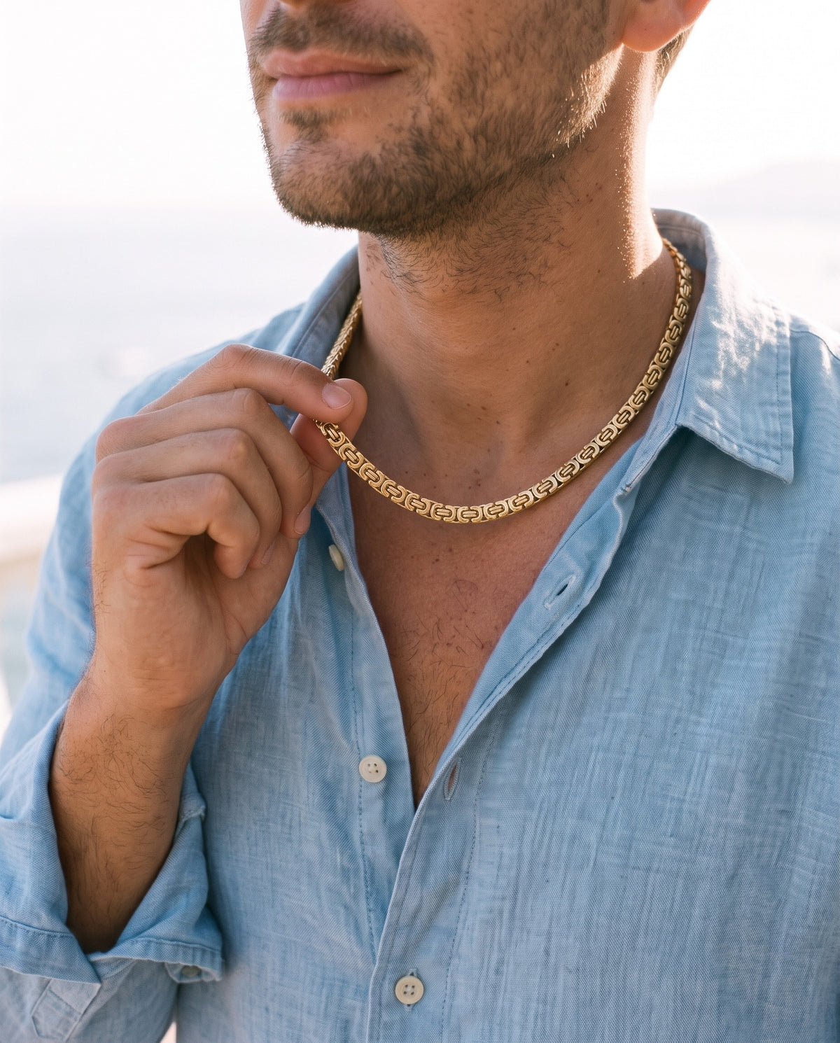 Man adjusting the Marco Maveri Byzantine Link Chain Necklace, close-up, Gold