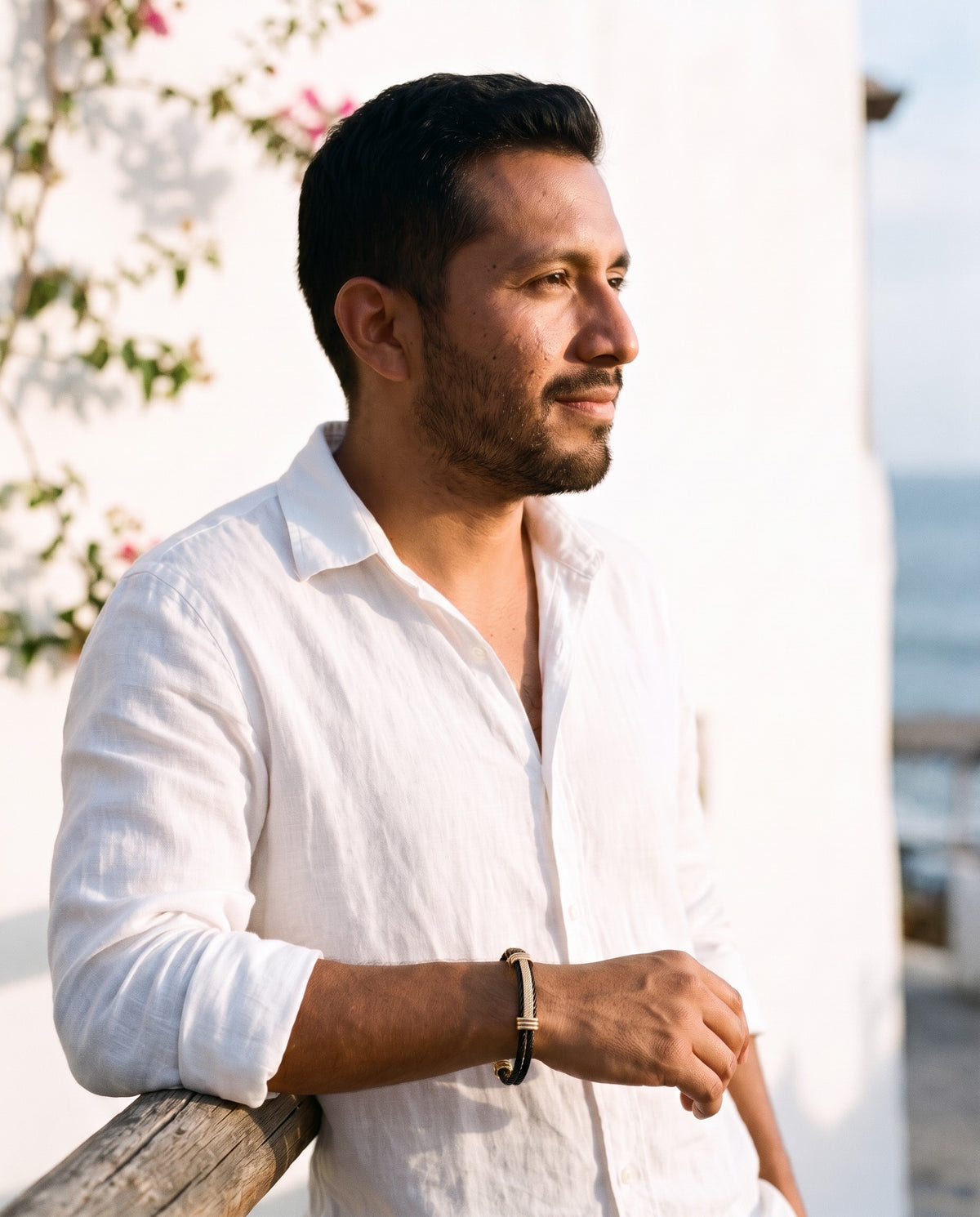 Man wearing the Marco Maveri Cable Cuff Bracelet by the sea, Black / Gold