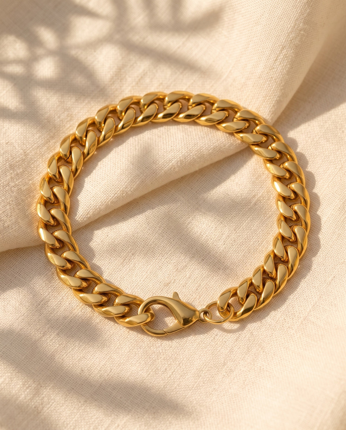Marco Maveri Chunky Curb Link Bracelet laid on cream linen, Gold