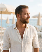 Man wearing the Marco Maveri Classic Cross Pendant Necklace by the sea, Gold