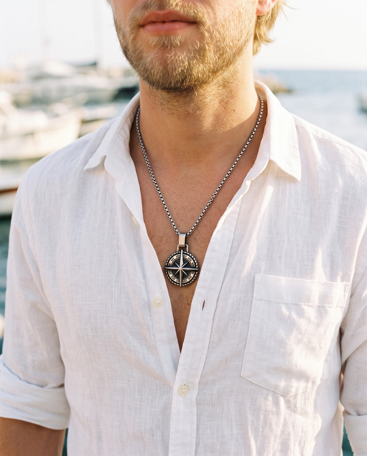 Marco Maveri Compass Pendant Necklace worn with a linen shirt, close-up, Silver