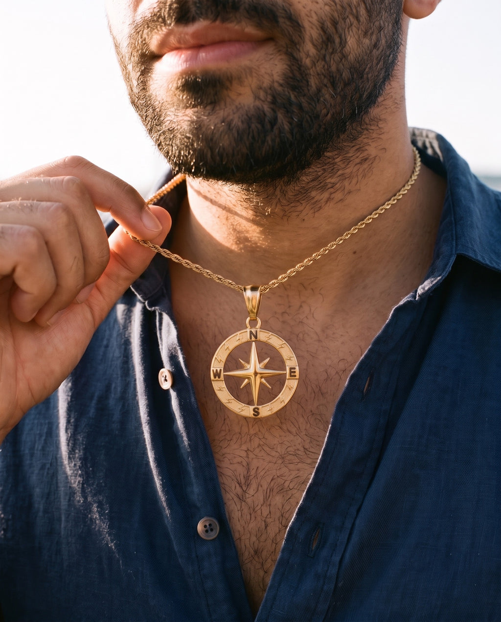 Man adjusting the Marco Maveri Compass Pendant Rope Chain Necklace, close-up, Gold