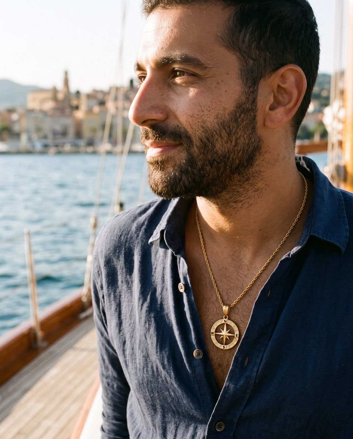 Man wearing the Marco Maveri Compass Pendant Rope Chain Necklace by the sea, Gold