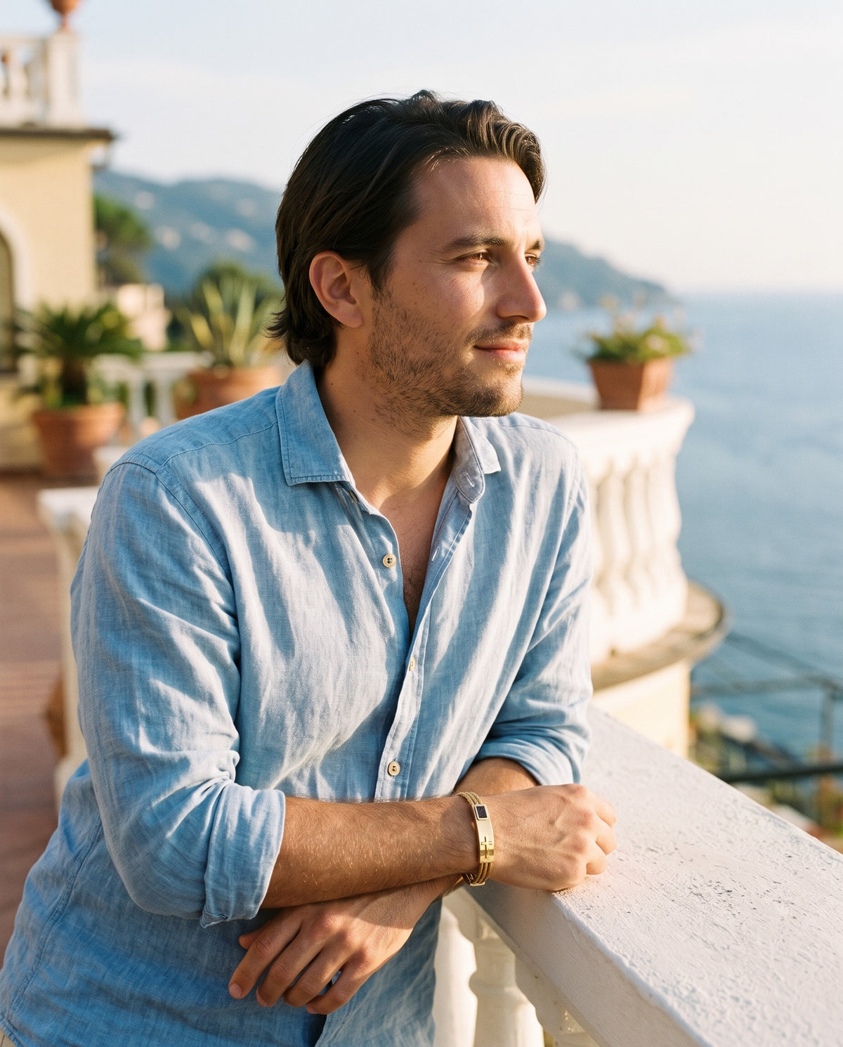 Man wearing the Marco Maveri Cross Inlay Titanium Steel Bracelet by the sea, Gold