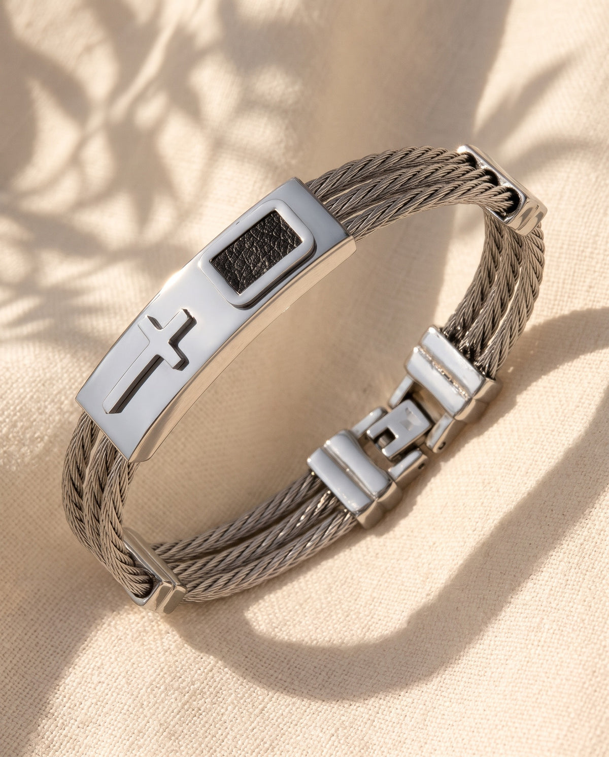 Marco Maveri Cross Inlay Titanium Steel Bracelet laid on cream linen, Silver