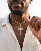 Man adjusting the Marco Maveri Cross Pendant Necklace with Cable Inlay, close-up, Gold