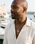 Man wearing the Marco Maveri Cross Pendant Necklace with Cable Inlay by the sea, Gold