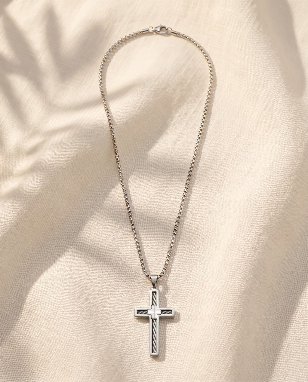 Marco Maveri Cross Pendant Necklace with Cable Inlay laid on cream linen, Silver