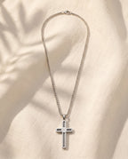 Marco Maveri Cross Pendant Necklace with Cable Inlay laid on cream linen, Silver