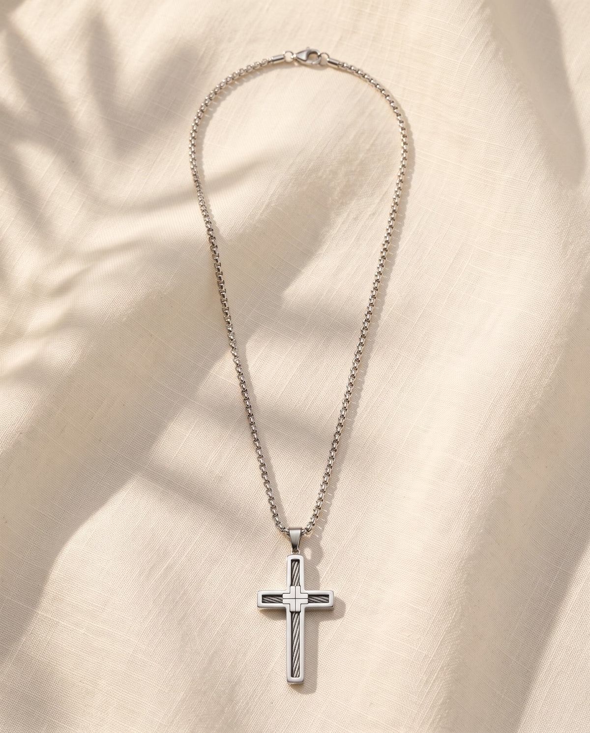 Marco Maveri Cross Pendant Necklace with Cable Inlay laid on cream linen, Silver