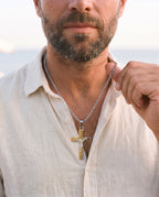 Man adjusting the Marco Maveri Crucifix Pendant Necklace in Titanium Steel, close-up, Gold