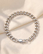 Marco Maveri Cuban Link Bracelet in Stainless Steel laid on cream linen, Silver