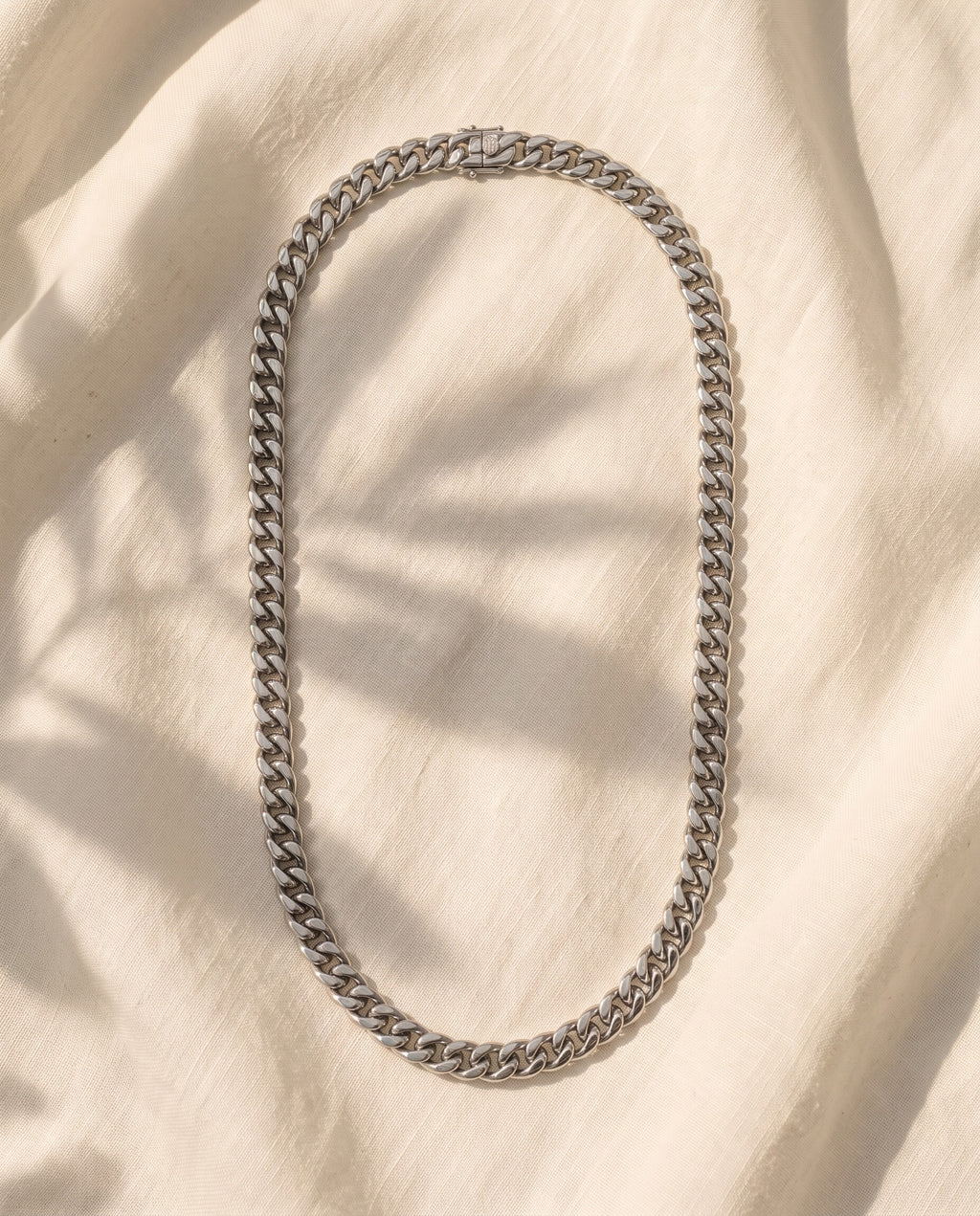 Marco Maveri Silver Cuban Link Chain laid on cream linen, Silver