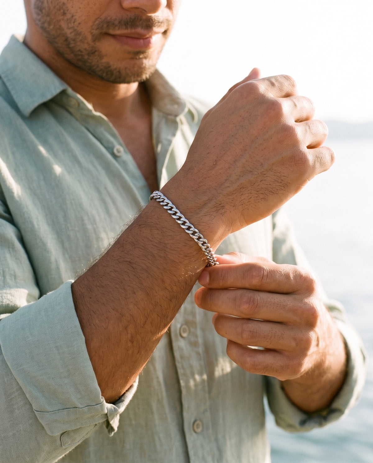 Man adjusting the Marco Maveri Cuban Link Chain Bracelet, close-up, Silver