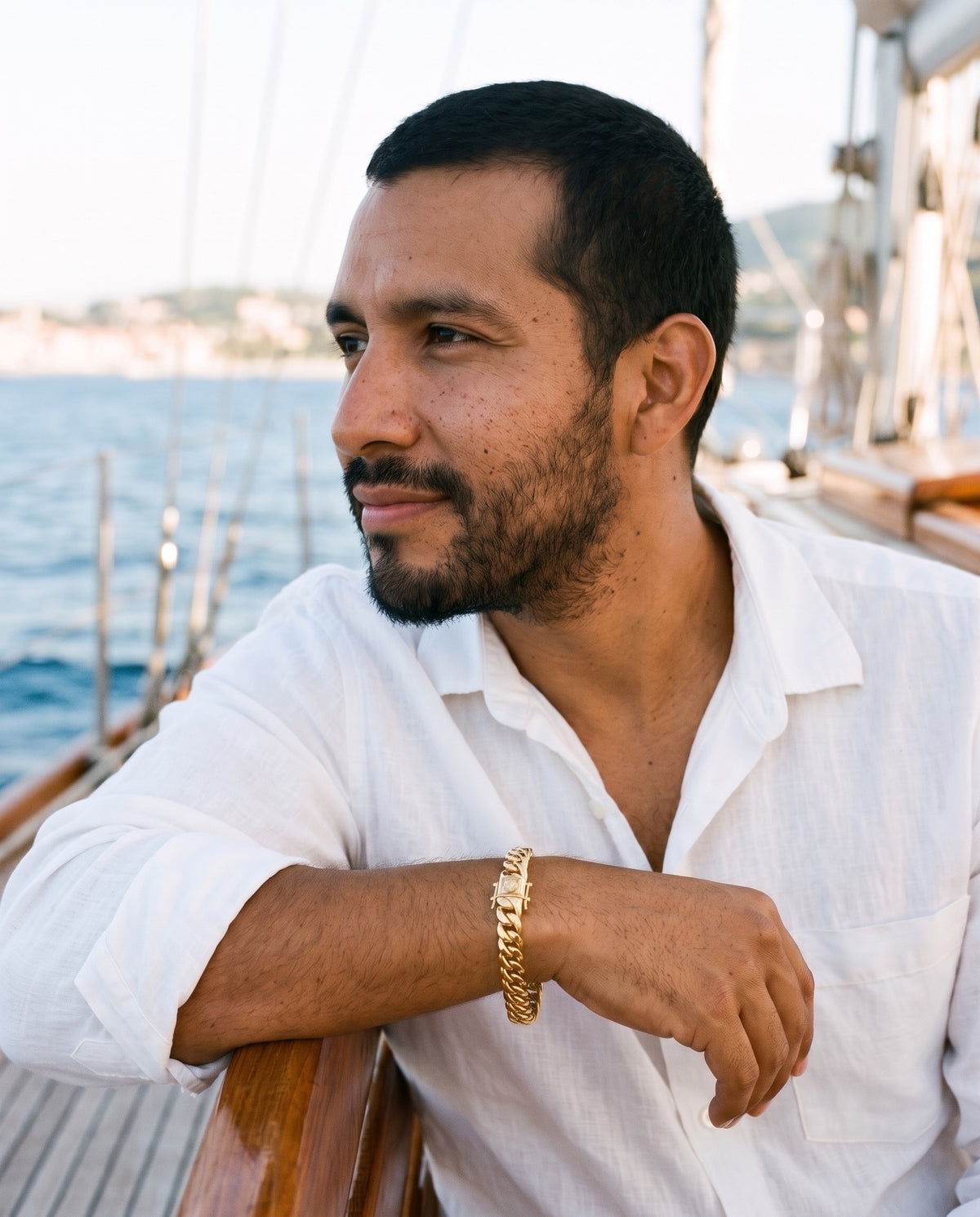 Man wearing the Marco Maveri Cuban Link Chain Bracelet with Box Clasp by the sea, Gold
