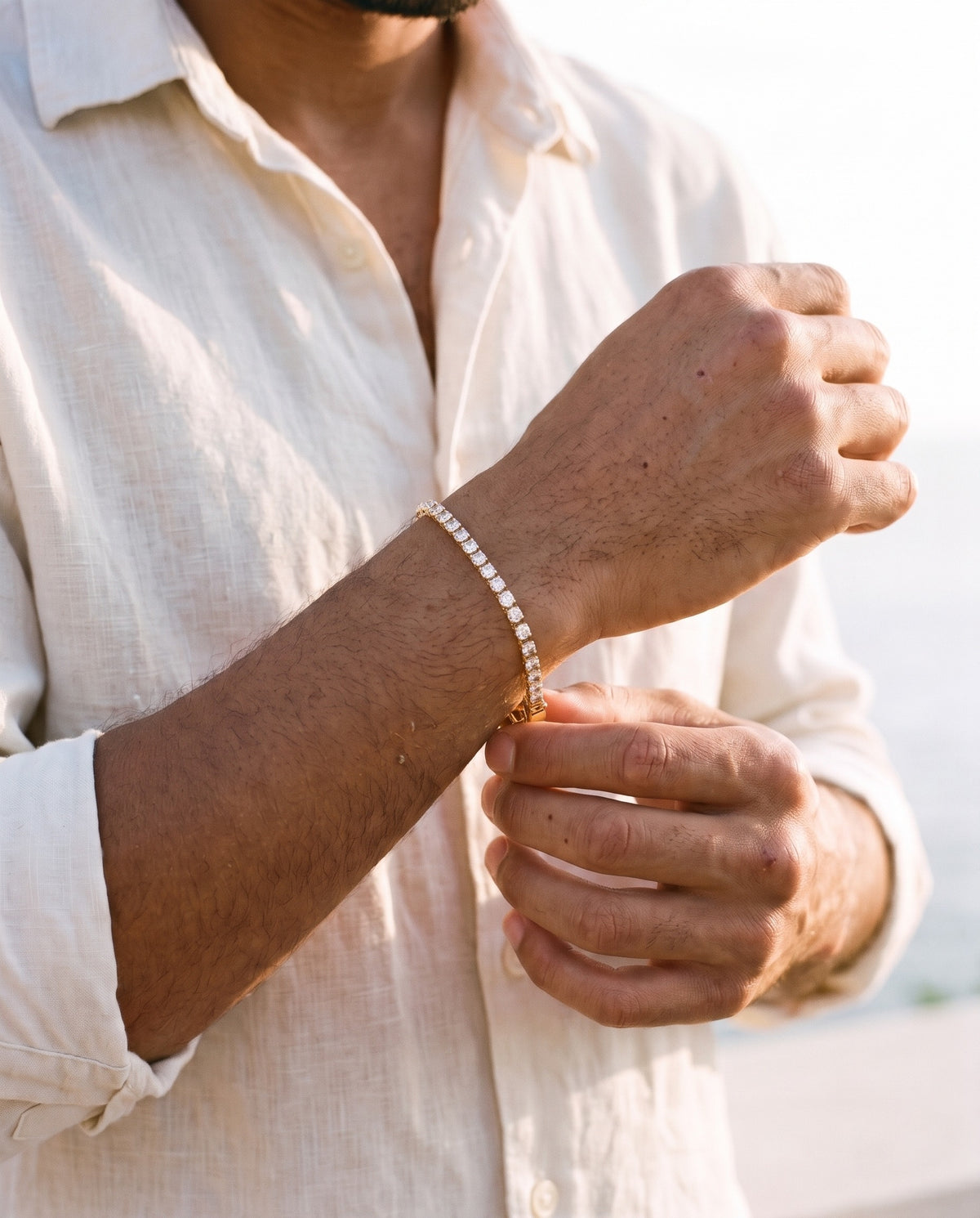 Man adjusting the Marco Maveri Cubic Zirconia Tennis Bracelet, close-up, Gold