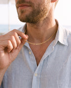 Man adjusting the Marco Maveri Figaro Chain in Stainless Steel, close-up, Gold