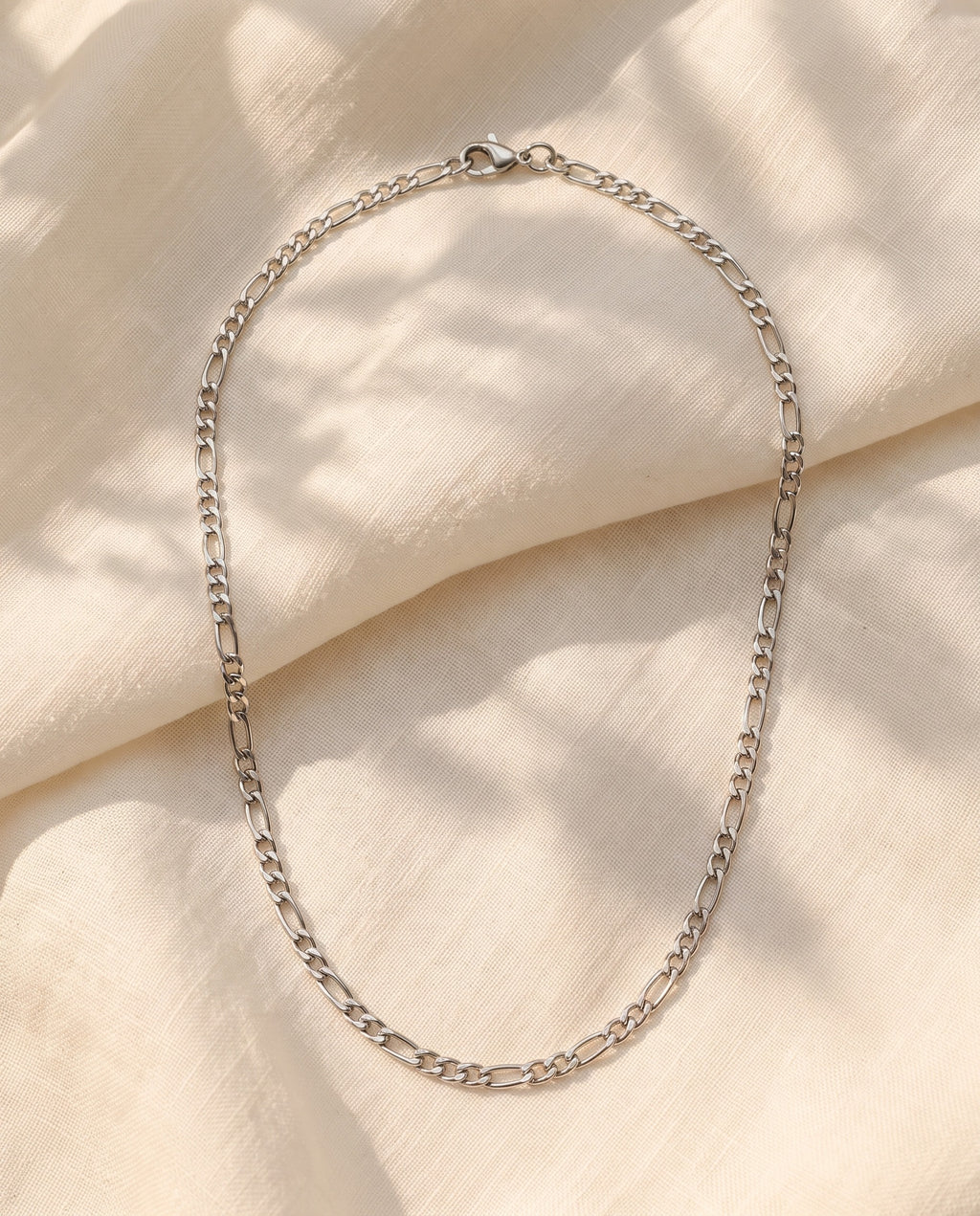 Marco Maveri Figaro Chain in Stainless Steel laid on cream linen, Silver