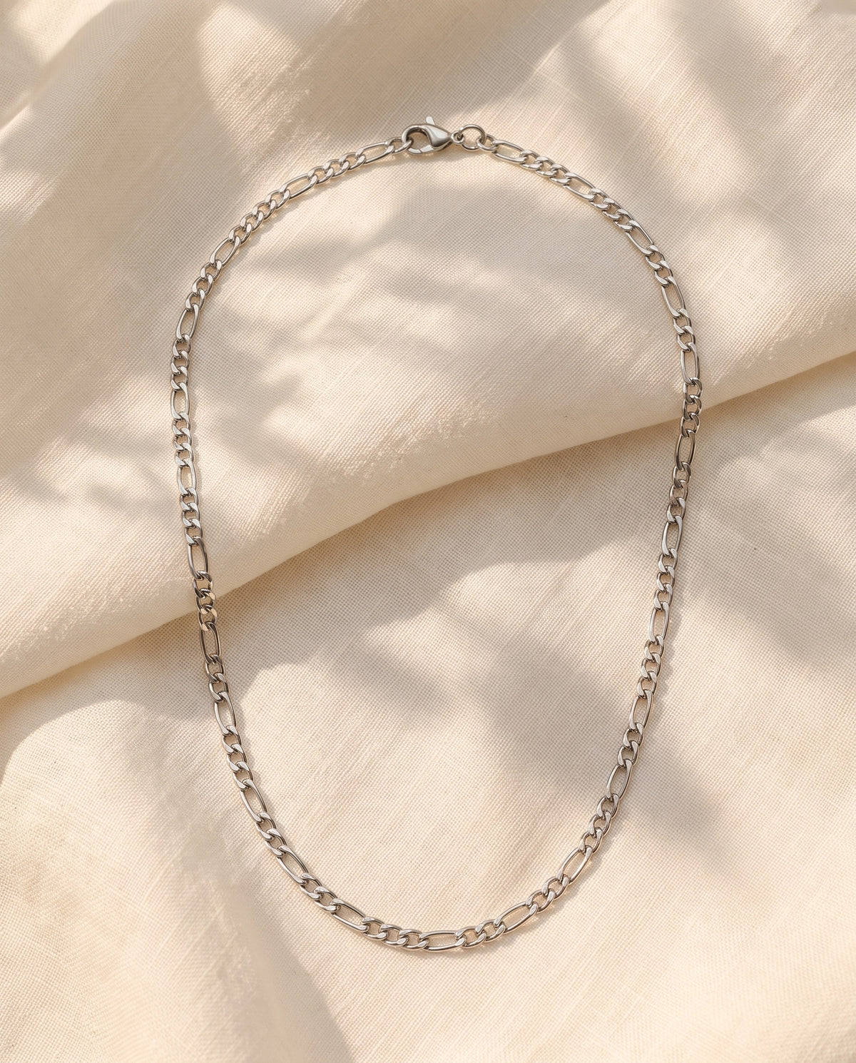 Marco Maveri Figaro Chain in Stainless Steel laid on cream linen, Silver