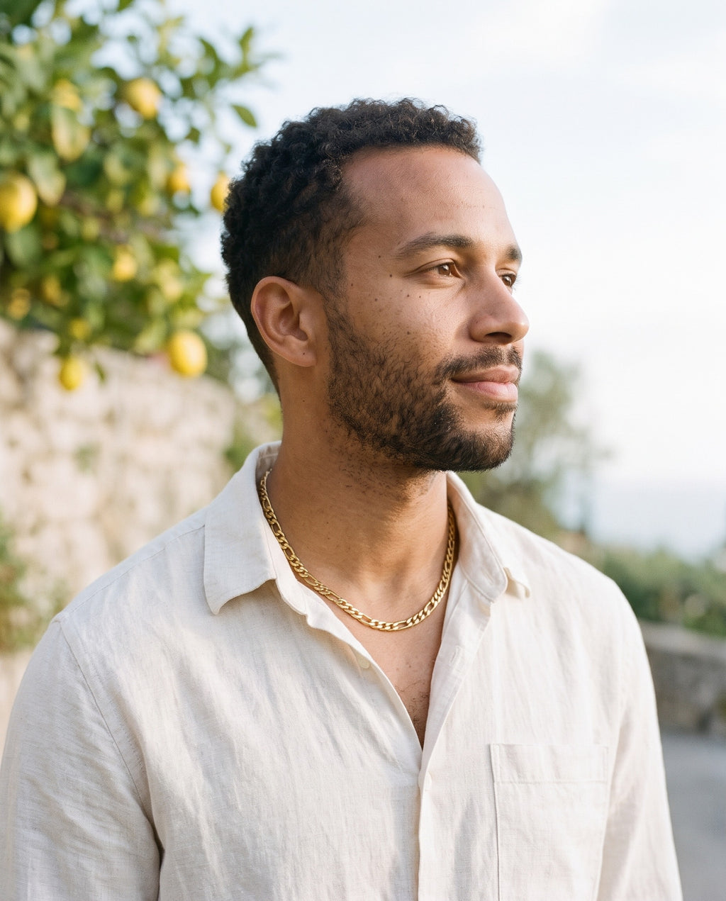Man wearing the Marco Maveri Figaro Chain Necklace in Stainless Steel by the sea, Gold