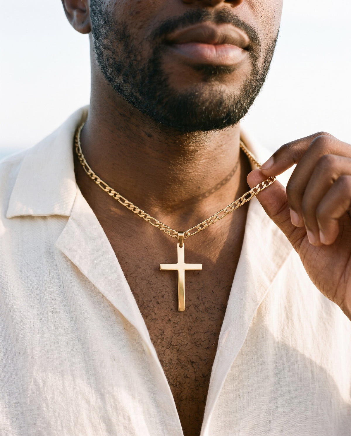 Man adjusting the Marco Maveri Figaro Chain with Cross Pendant, close-up, Gold