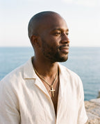 Man wearing the Marco Maveri Figaro Chain with Cross Pendant by the sea, Gold