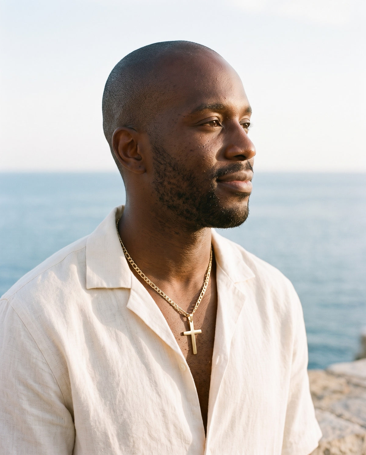 Man wearing the Marco Maveri Figaro Chain with Cross Pendant by the sea, Gold