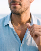 Man adjusting the Marco Maveri Figaro Link Chain Necklace, close-up, Gold