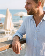 Man wearing the Marco Maveri Flat Snake Chain Bracelet by the sea, Gold
