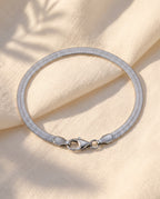 Marco Maveri Flat Snake Chain Bracelet laid on cream linen, Silver