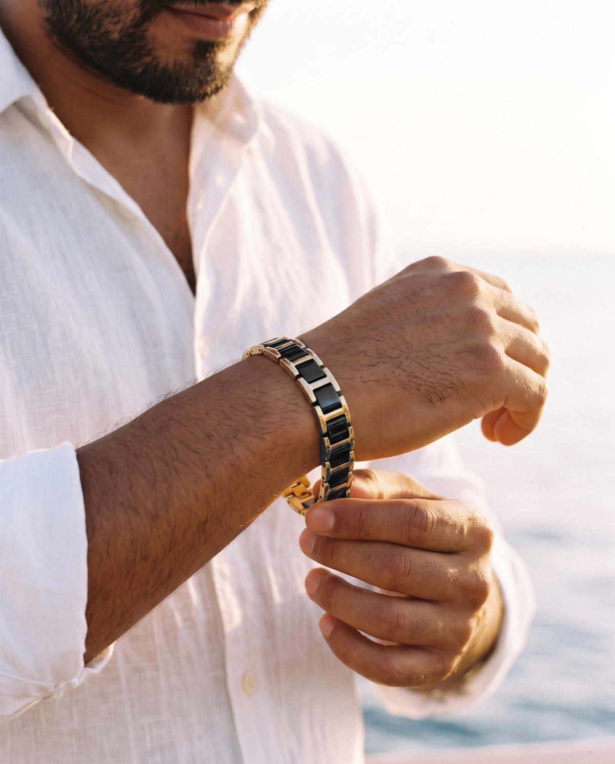 Man adjusting the Marco Maveri Geometric Link Bracelet with Ceramic Inlay, close-up, Black / Gold