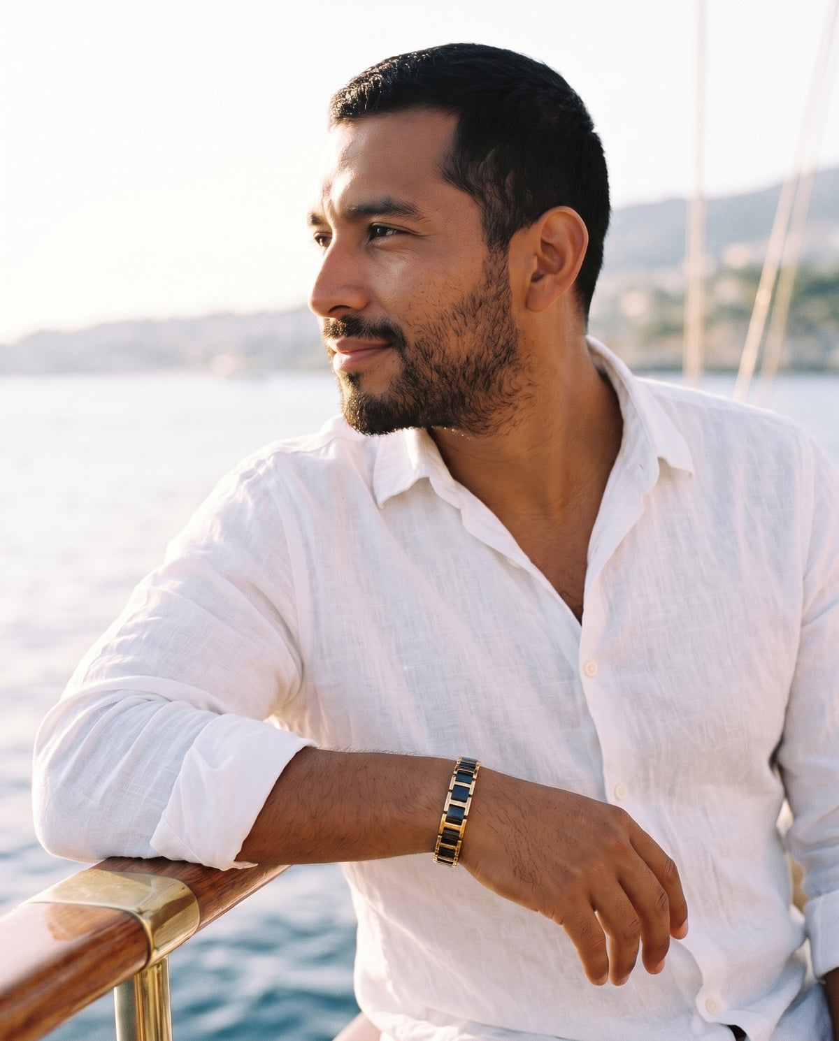 Man wearing the Marco Maveri Geometric Link Bracelet with Ceramic Inlay by the sea, Black / Gold