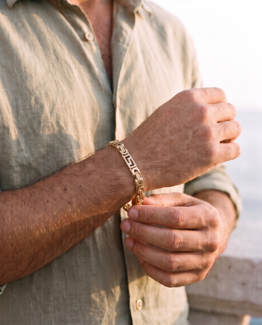 Man adjusting the Marco Maveri Geometric Link Byzantine Bracelet, close-up, Gold