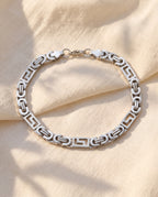 Marco Maveri Geometric Link Byzantine Bracelet laid on cream linen, Silver