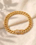 Marco Maveri Gold-Tone Cuban Link Bracelet laid on cream linen, Gold