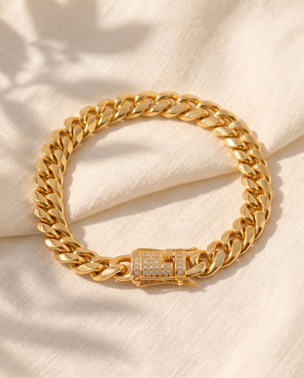 Marco Maveri Gold-Tone Cuban Link Bracelet laid on cream linen, Gold
