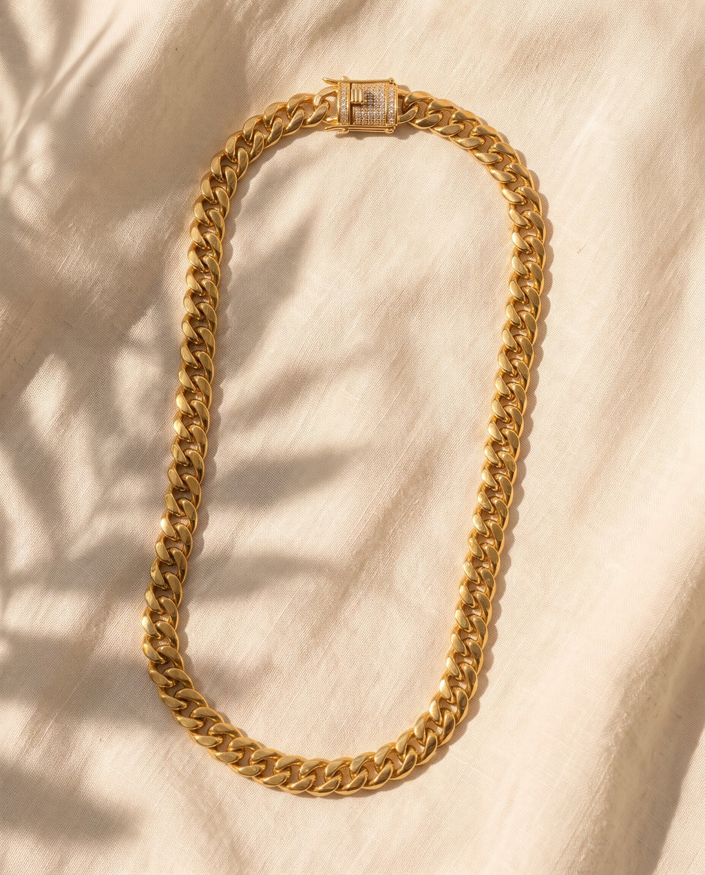 Marco Maveri Gold-Tone Cuban Link Chain laid on cream linen, Gold