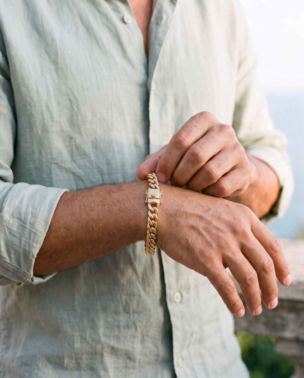Man adjusting the Marco Maveri Heavy Curb Chain Bracelet, close-up, Gold